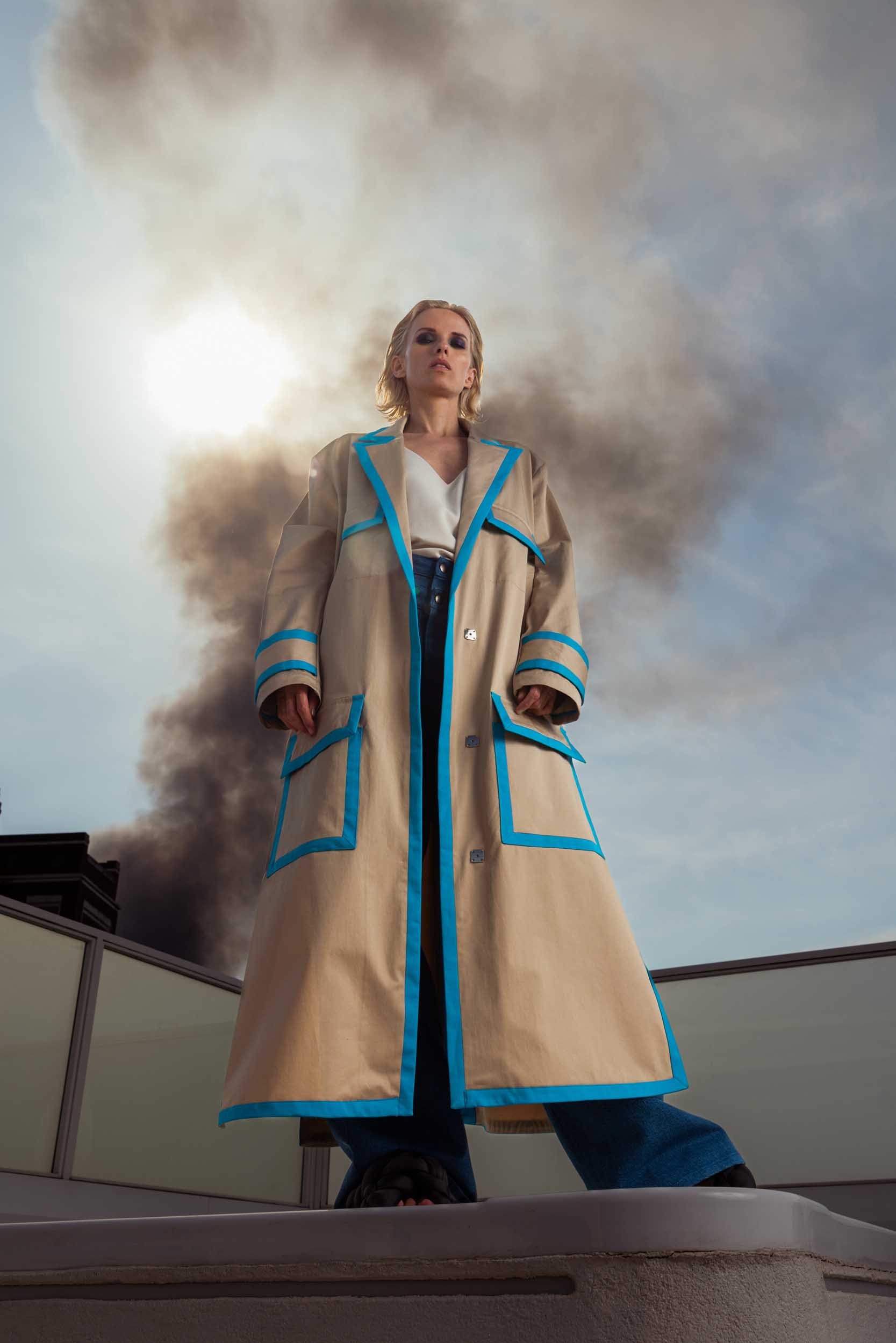 Eine Frau in extravaganter Mode mit Rauch im Hintergrund